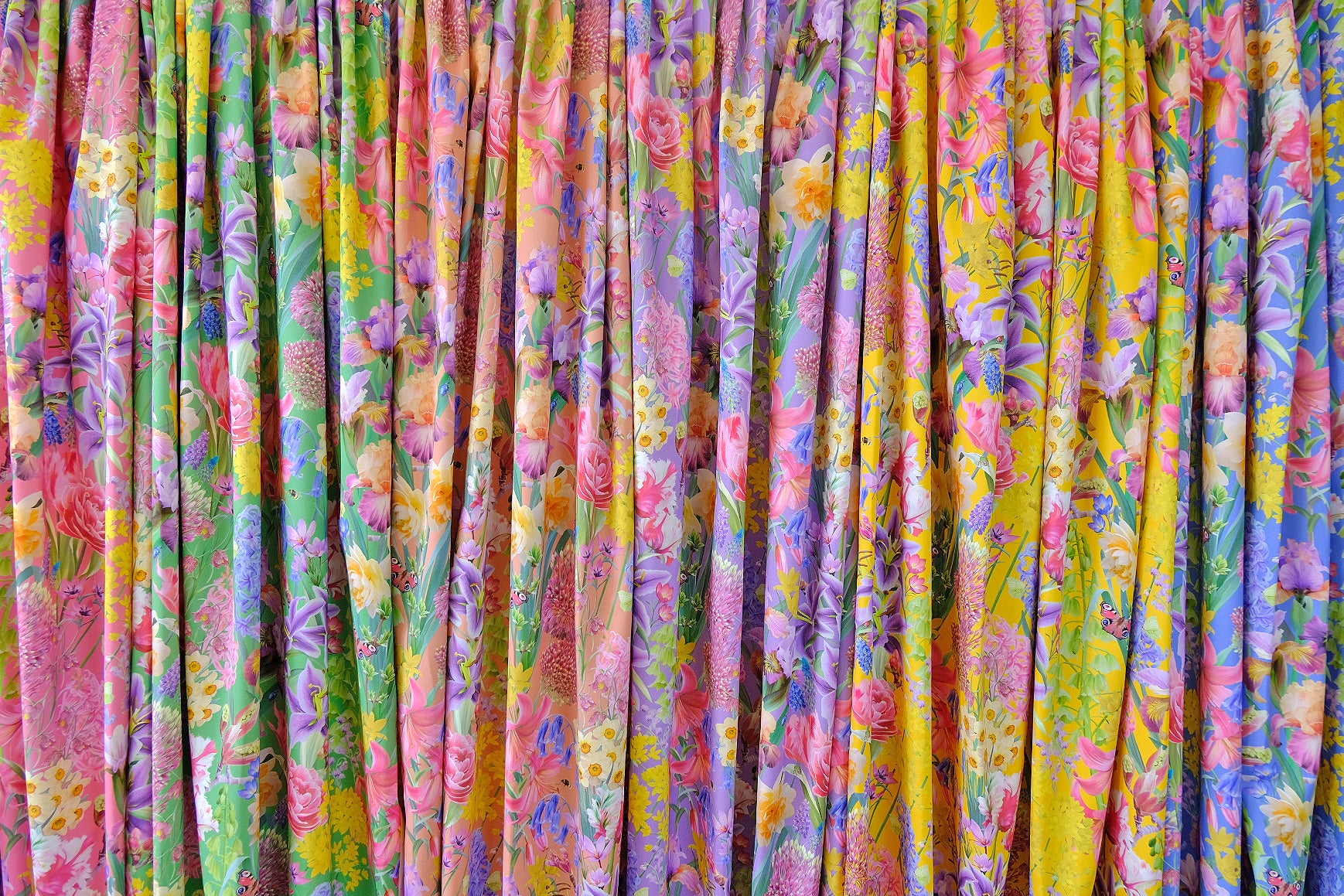 Sustainable and vegan interior and fashion fabrics with a designer floral patterned motif. In blue, green, yellow, peach, pink and purple.