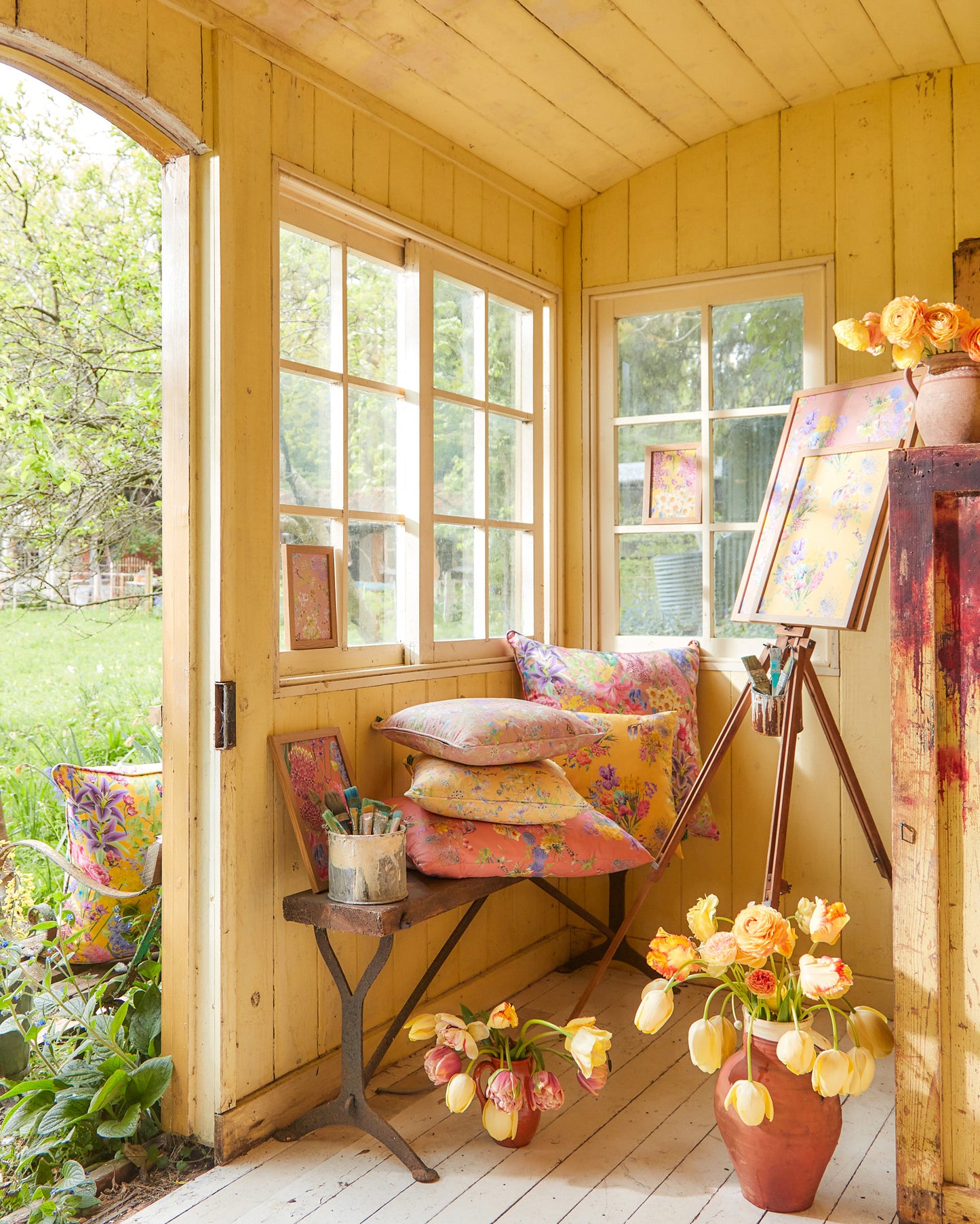 Burst Into Bloom peach floral fabric cushions and wallpaper by Bauldry Botanicals styled in a sunlit artists studio with seasonal florals.