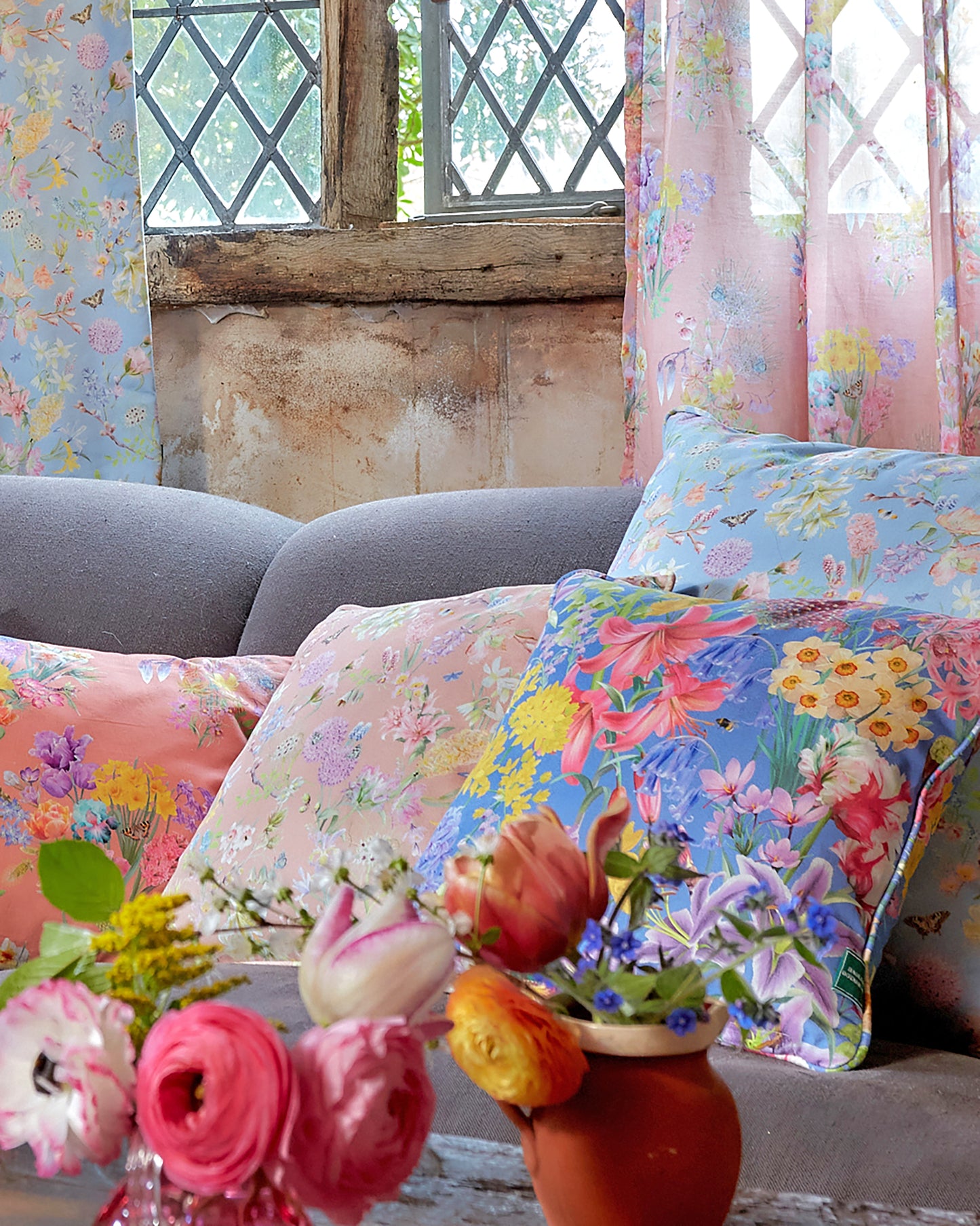 An English cottage style home with inspiring floral luxury cushions in blue and peach