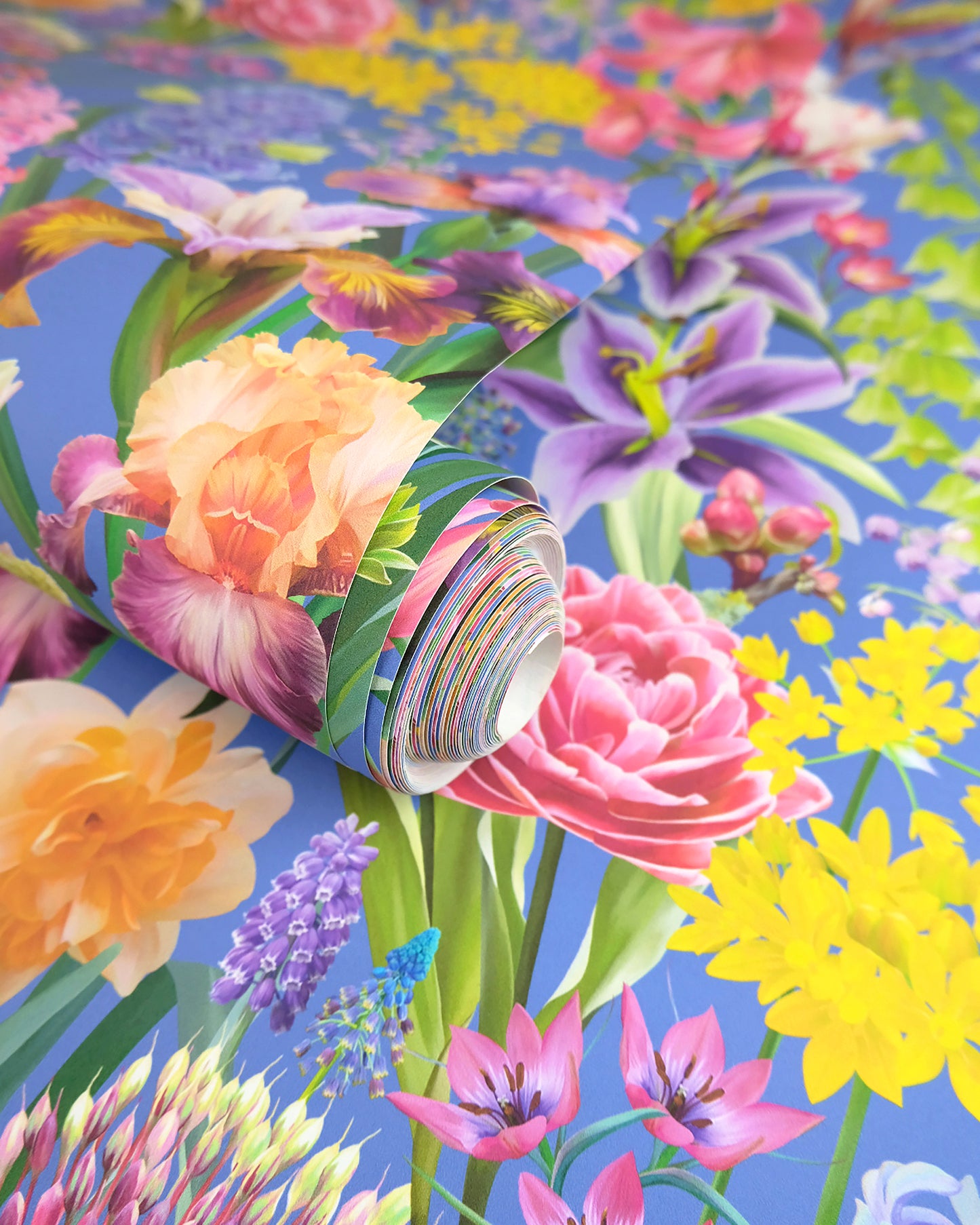 A roll of maximalist designer wall covering in dark blue with a spring botanical print for traditional interiors