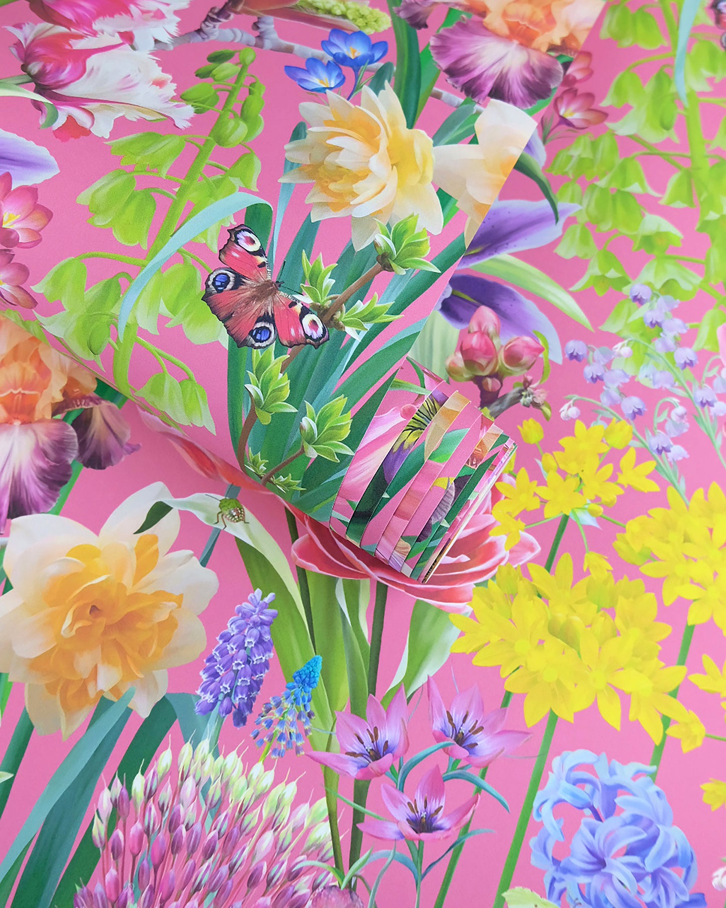 A roll of maximalist designer wall covering in fuchsia pink with a large botanical print for modern interiors