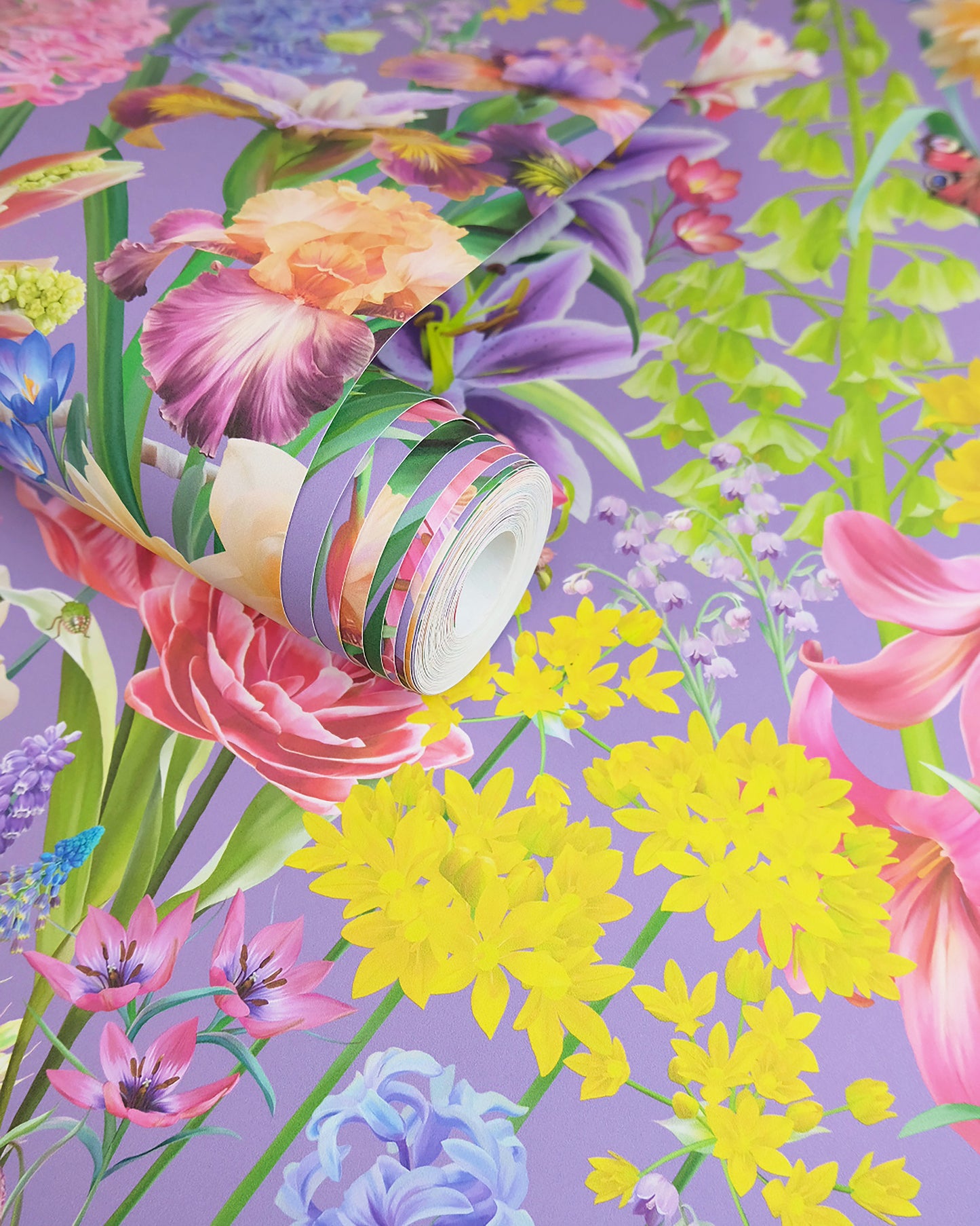 A roll of maximalist designer wall covering in dark purple with a spring botanical print for character interiors