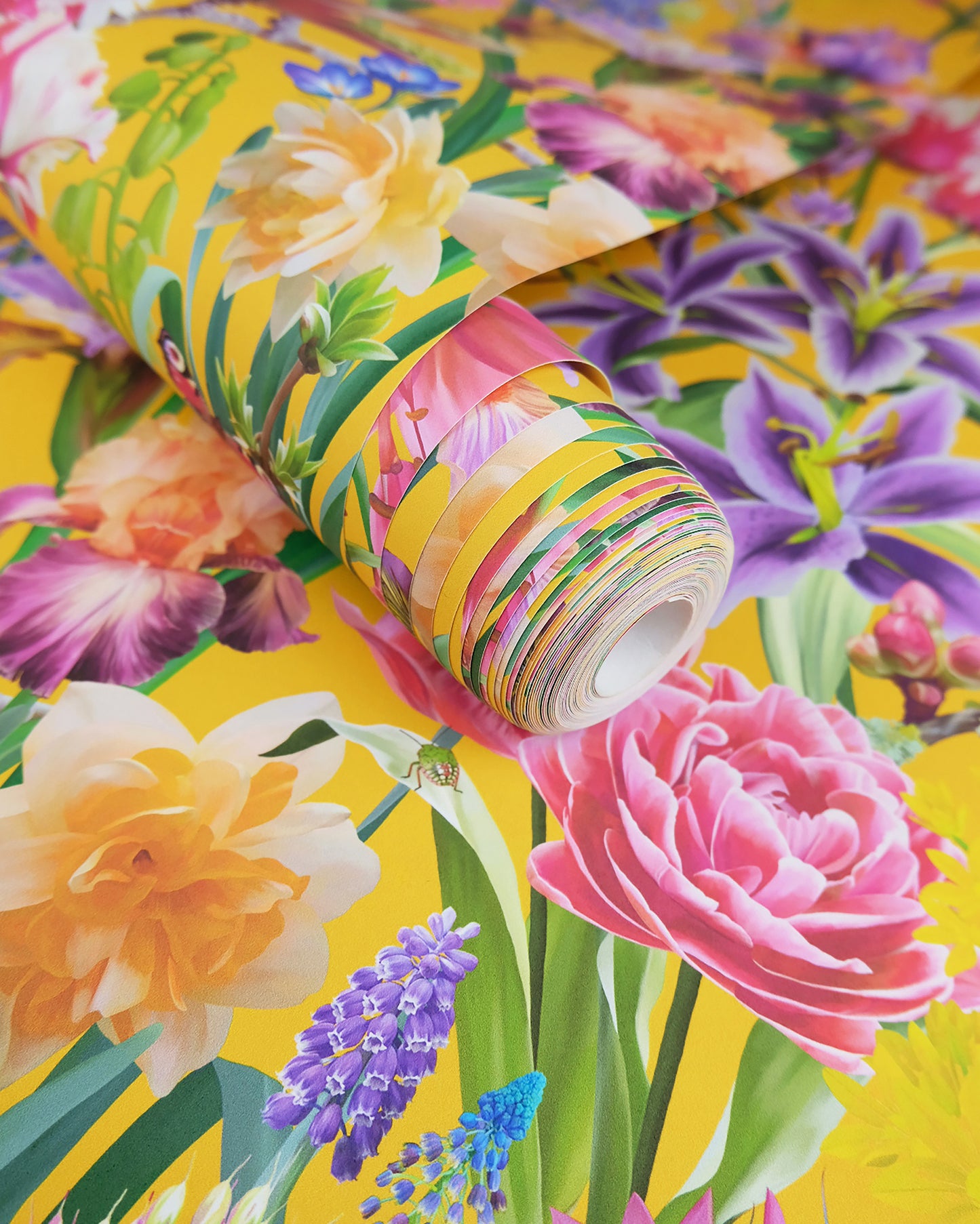 A roll of maximalist designer wall covering in mustard yellow with a spring botanical print for cottage interiors