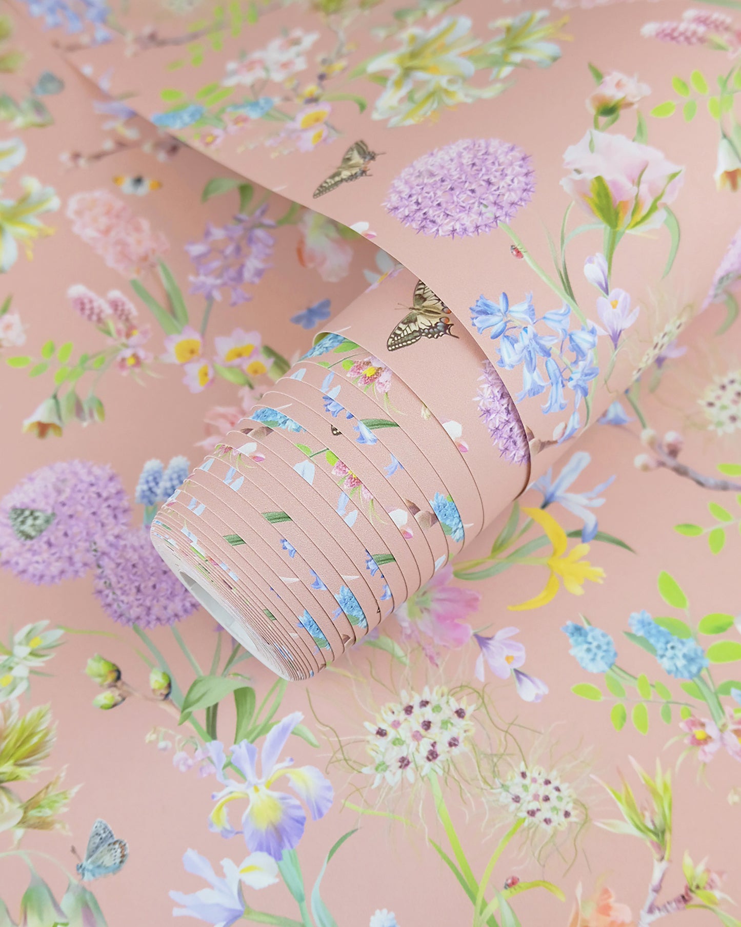 A roll of pale neutral wallpaper with a spring botanical print for cottage interior design