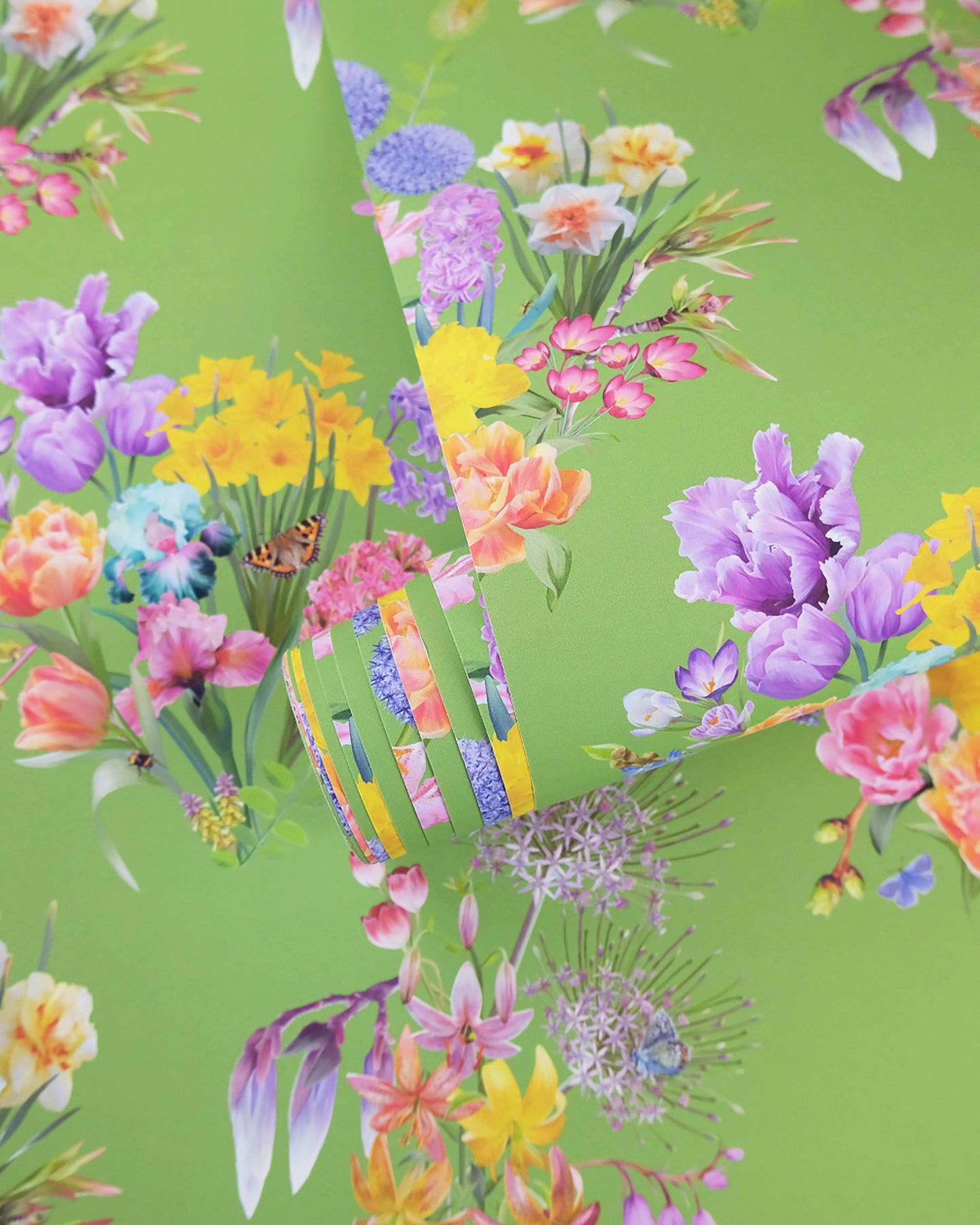 A roll of maximalist designer wall covering in mint green with a summer botanical print for contemporary interiors