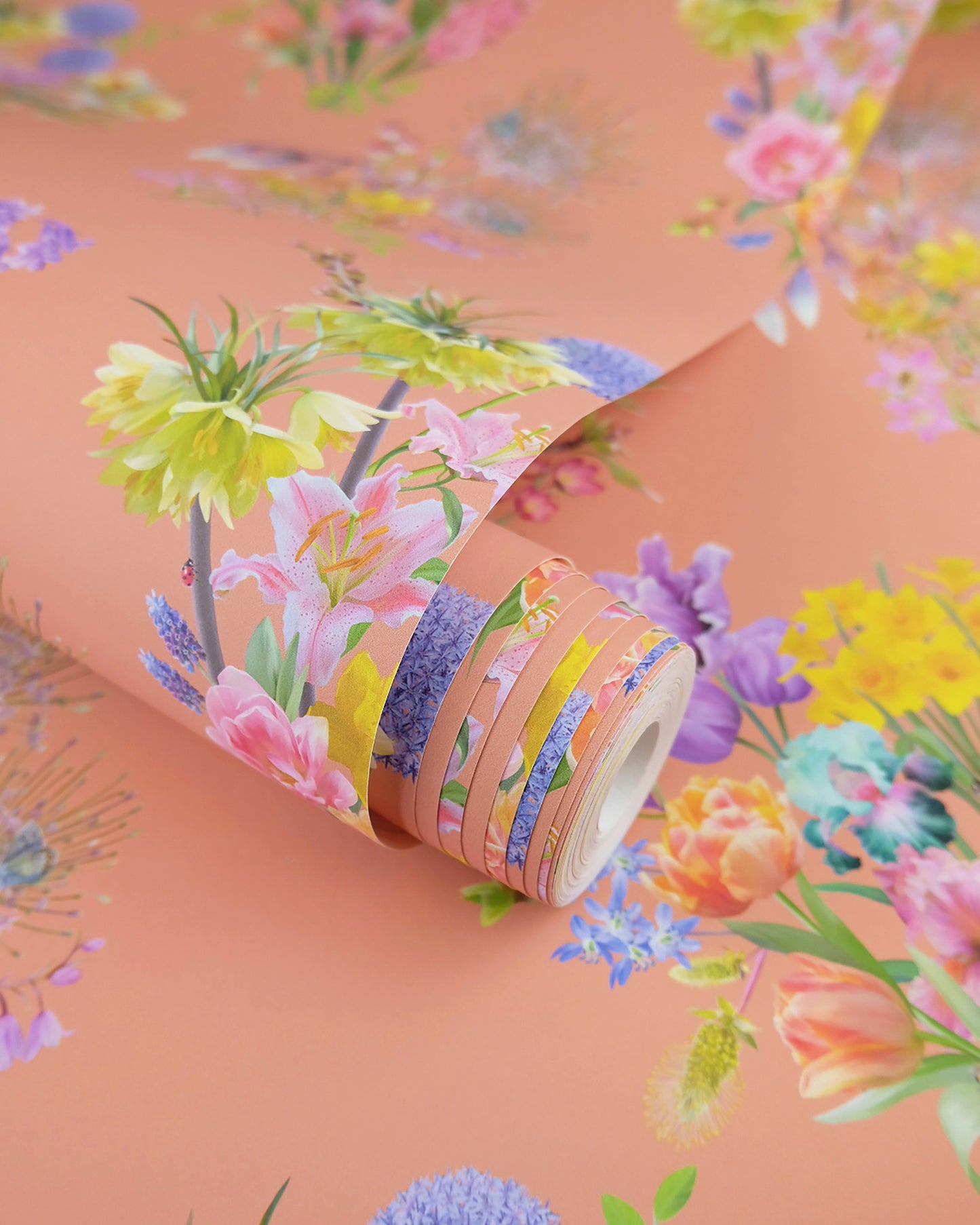 A roll of maximalist designer wall covering in bright cream with a spring botanical print for modern interiors