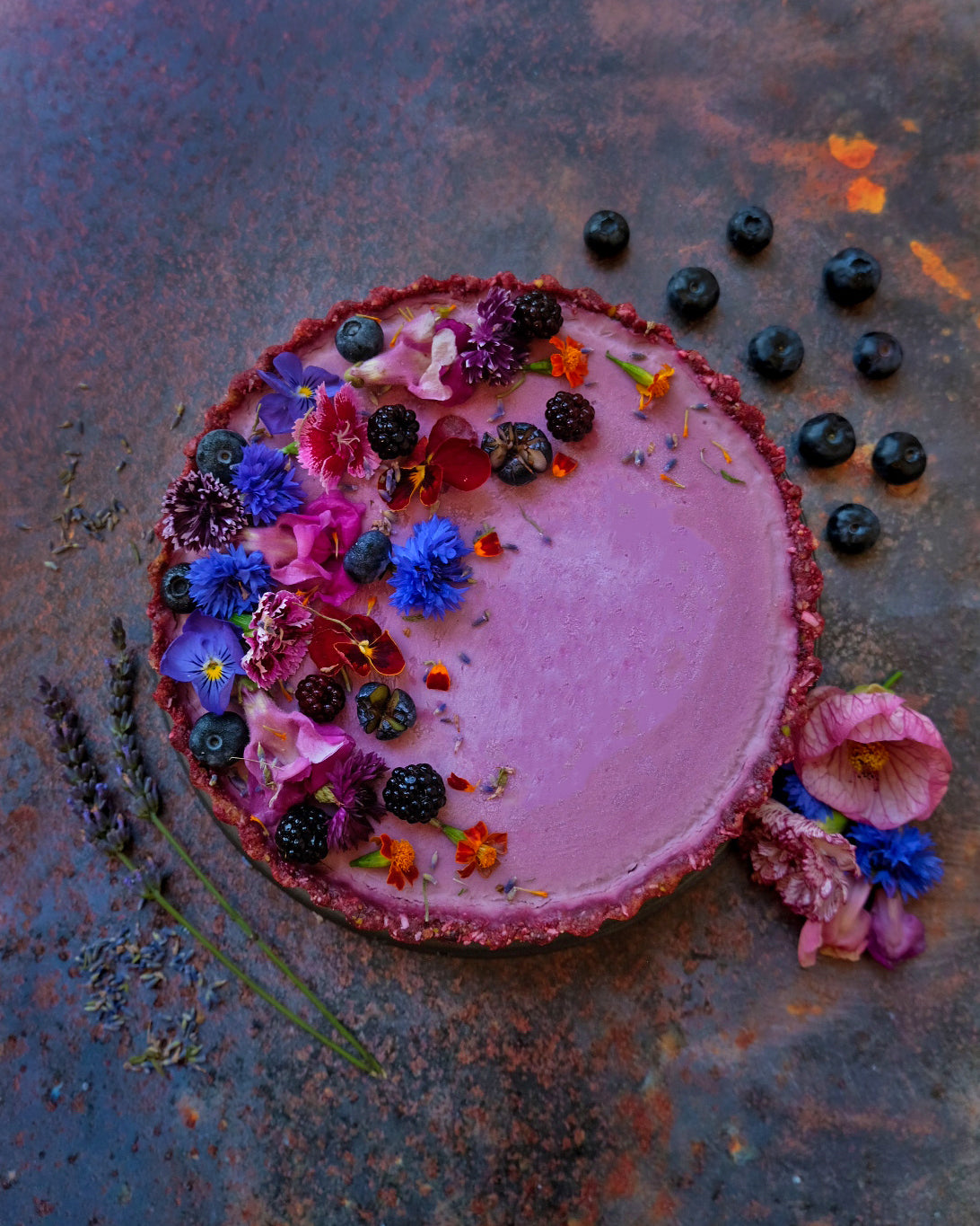 vegan antioxidant boosted foraged berry tart with edible flowers, a healthy dessert