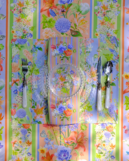Colourful floral-patterned tablecloth with cutlery on a striped background