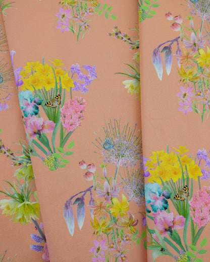Natural cotton textile in a daffodil, tulip and spring bulb warm peach print for holiday cottages and home renovation.