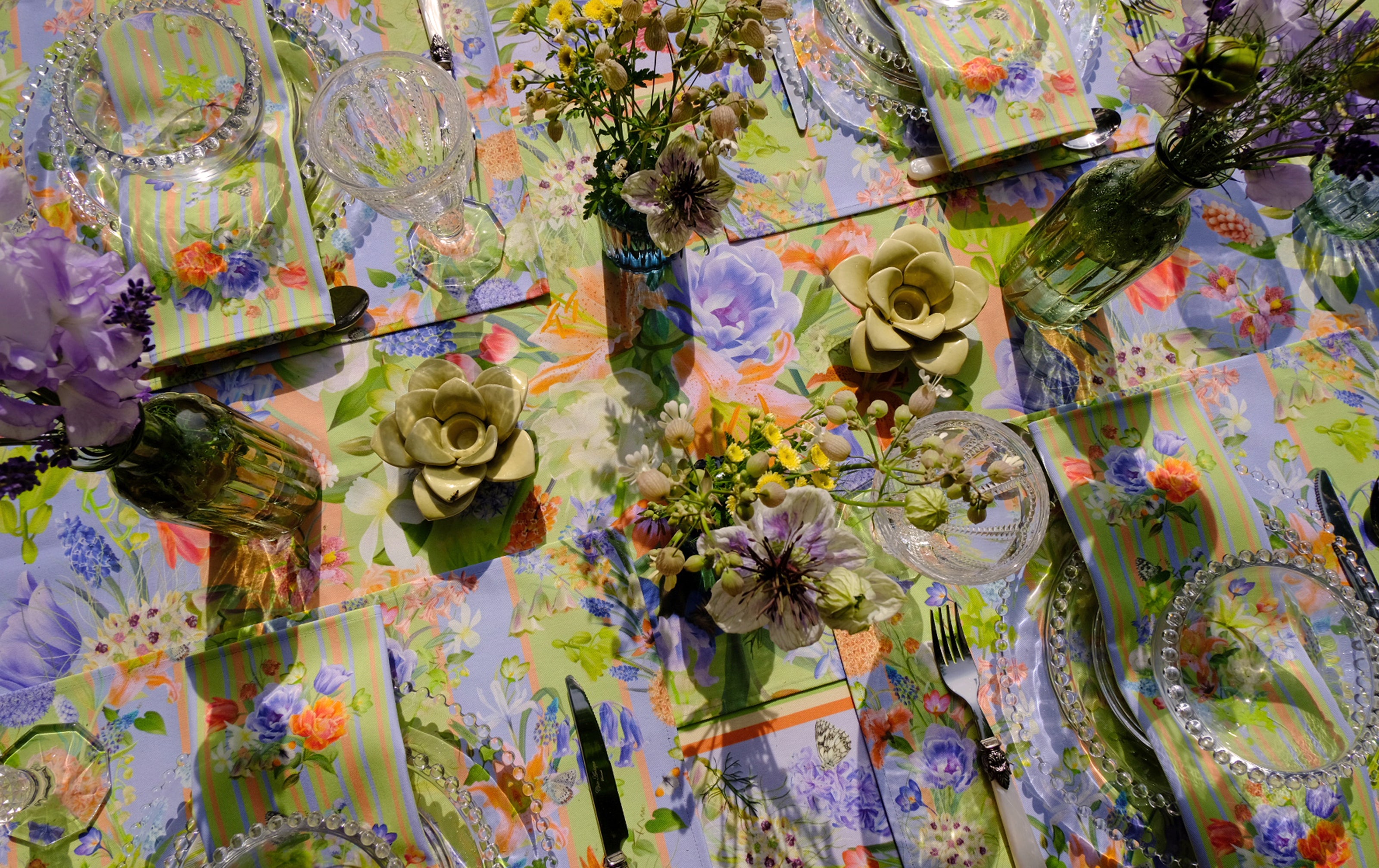 Colorful table setting with floral arrangements and patterned tablecloth