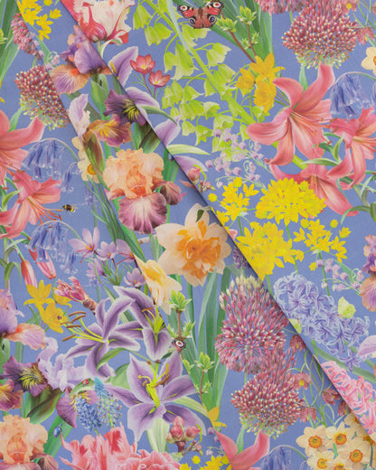 Burst Into Bloom Purple botanical floral fabric featuring hand painted daffodils, crocus and summer flowers in lavender, fuchsia and gold on a bright cobalt background.