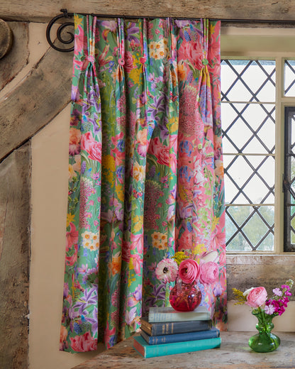 Burst Into Bloom Green floral curtains by Bauldry Botanicals featuring colourful botanical flowers on a bold grass green background, styled in a traditional country cottage interior.