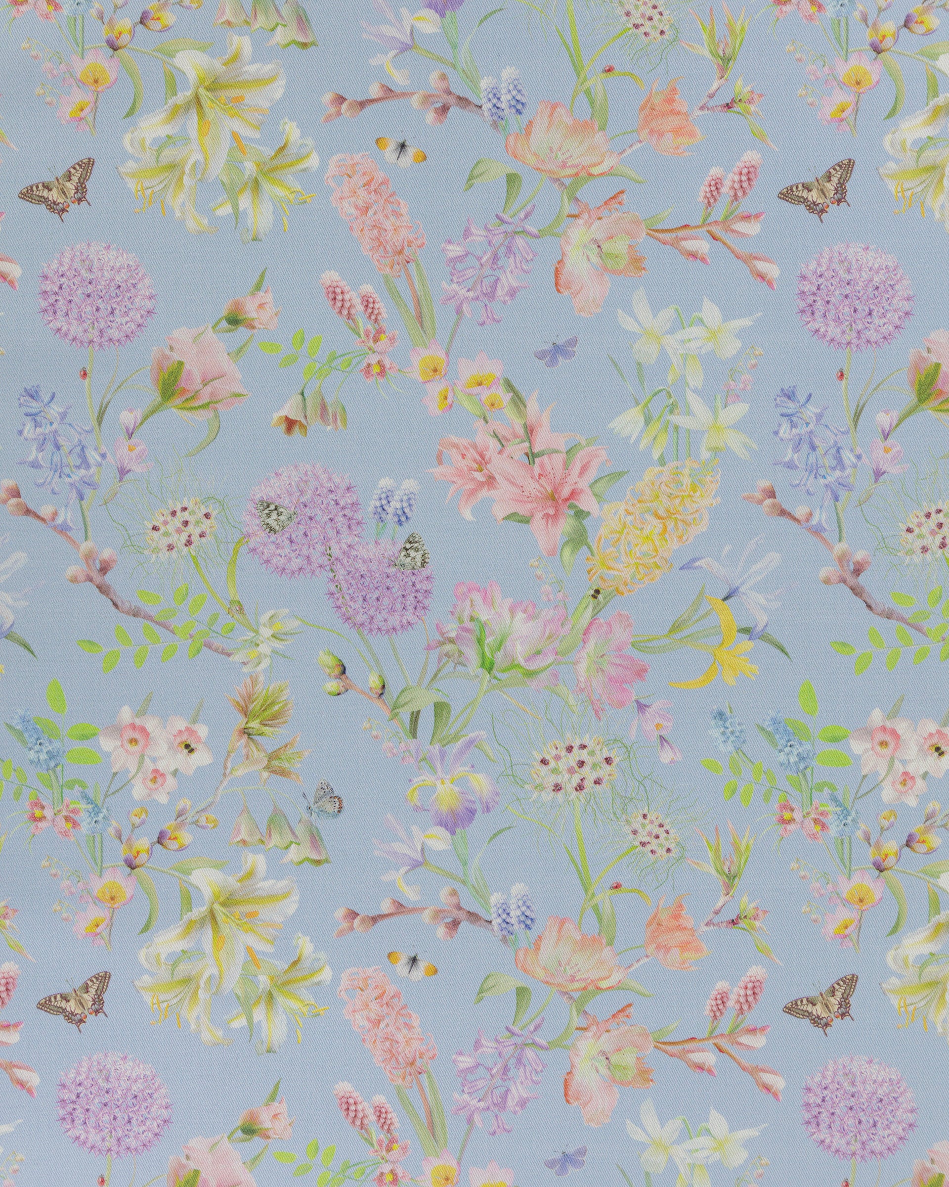 Hopeful Beginnings fabric in blue featuring hand drawn English garden flowers including daffodils, Lillies and iris on a pale blue background.
