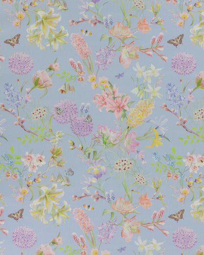 Hopeful Beginnings fabric in blue featuring hand drawn English garden flowers including daffodils, Lillies and iris on a pale blue background.