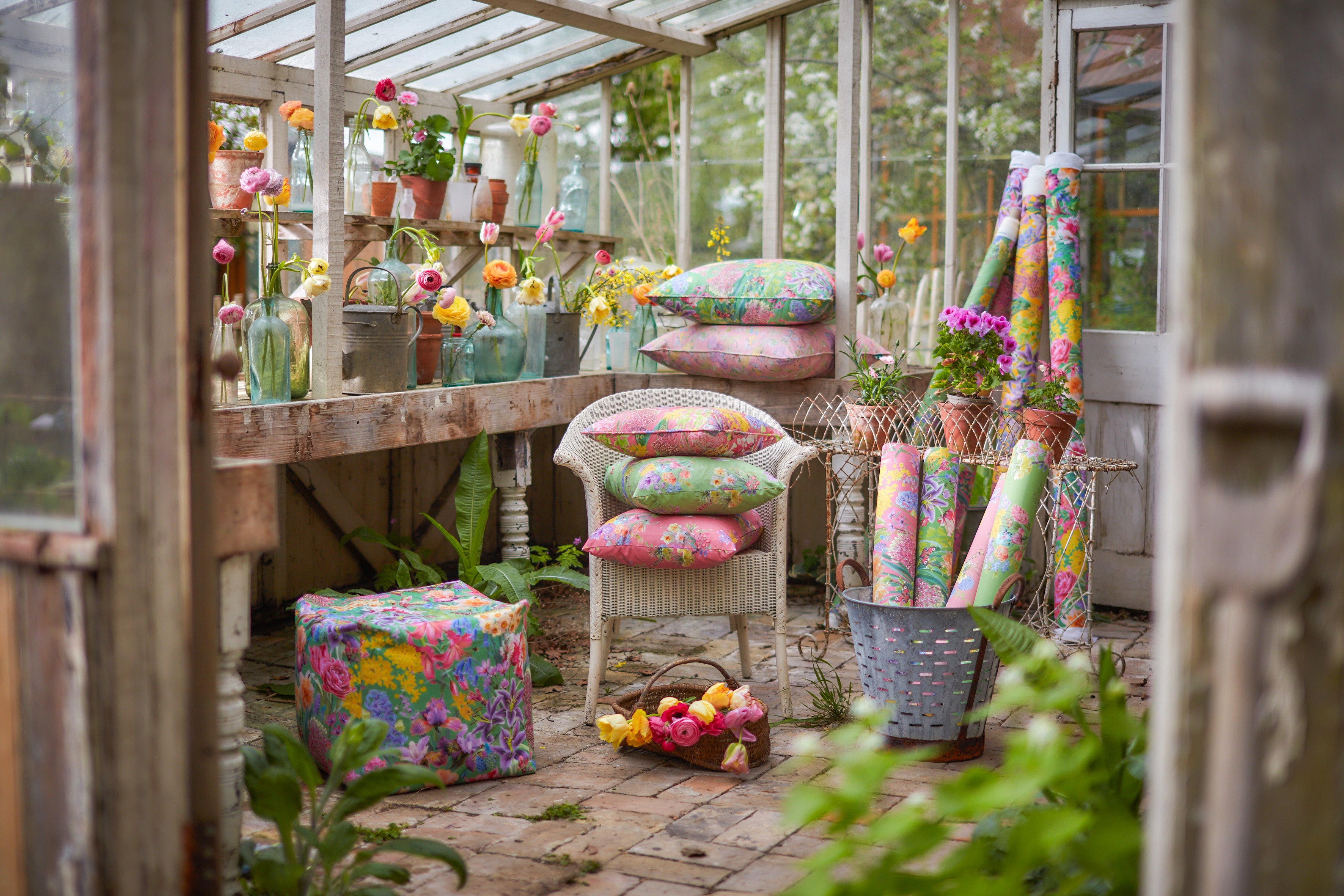 Hopeful Beginnings and Burst Into Bloom interiors styling featuring botanical fabric, floral cushions and colourful wallpaper in a greenhouse inspired by spring and summer flowers.