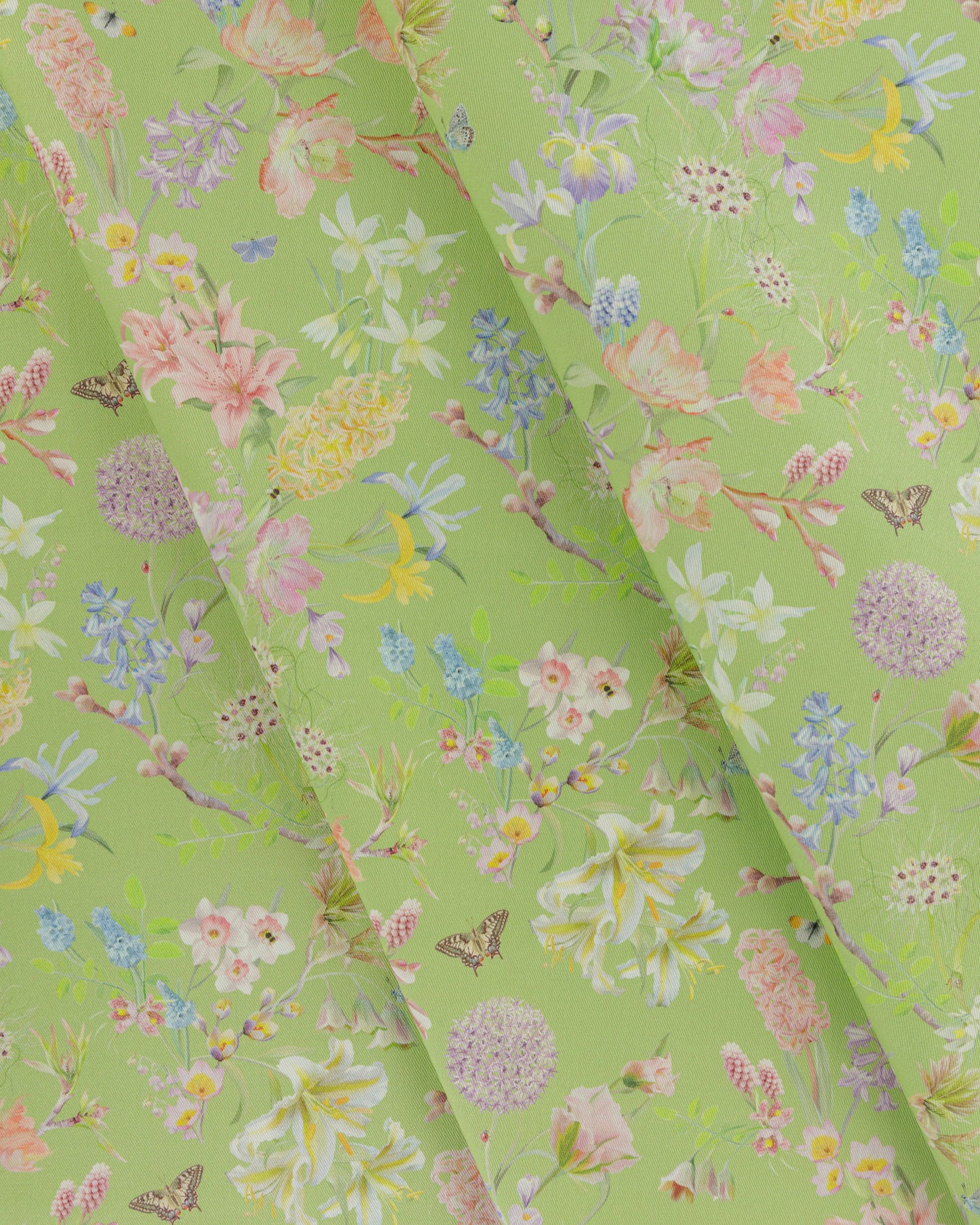 Draped Hopeful Beginnings cotton twill fabric in green showing detailed botanical floral pattern.
