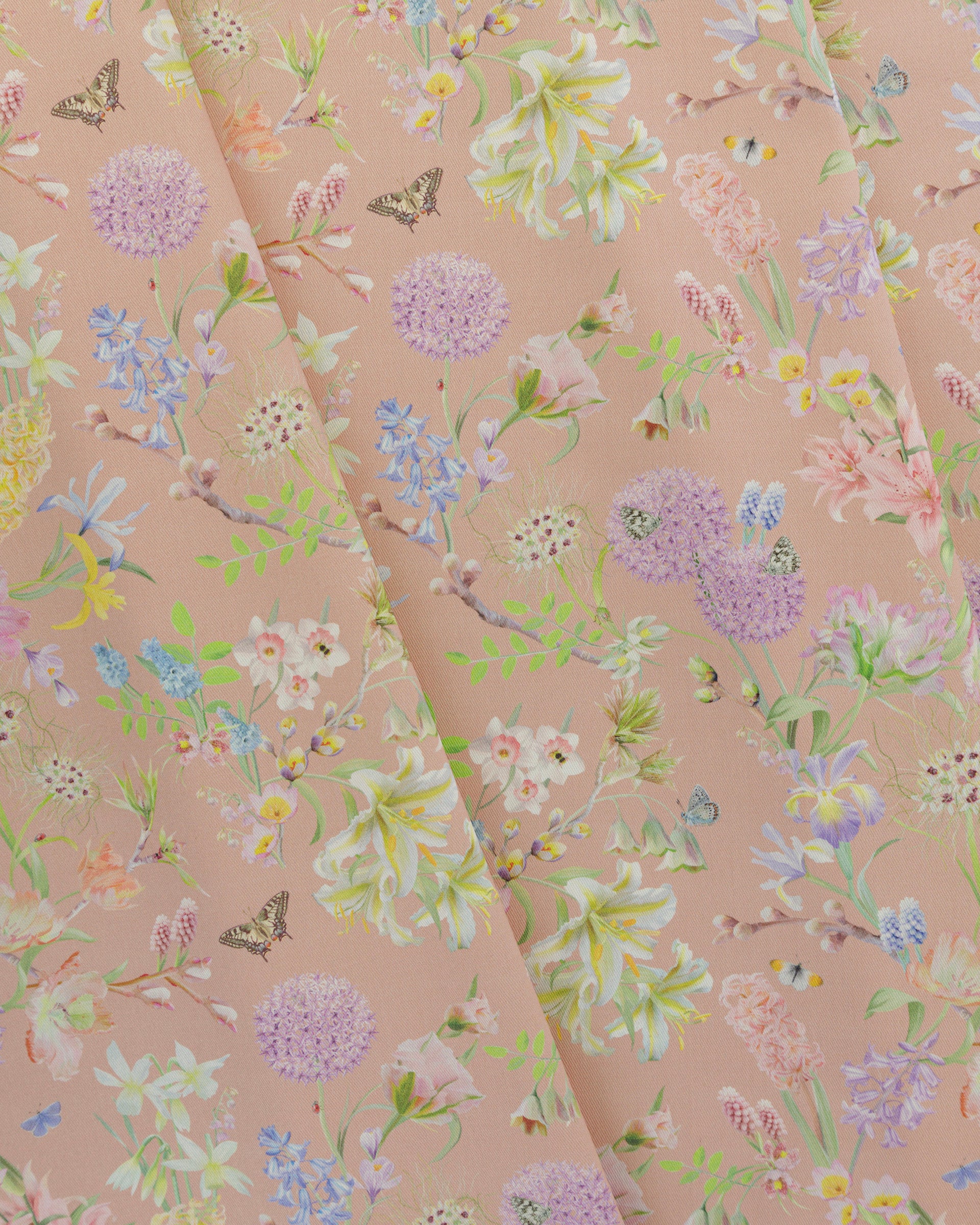 Draped Hopeful Beginnings cotton twill furnishing fabric in pastel peach showing detailed botanical floral pattern.