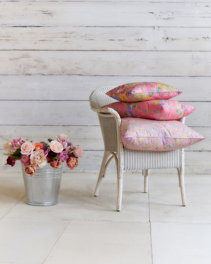 Chair styled with decorative cushions made from Hopeful Beginnings pale pink botanical fabric, showcasing the floral print at furnishing scale.