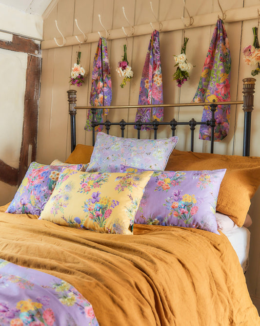 Bedroom featuring hopeful beginnings curtains in purple with floral fabric and coordinating cushions.