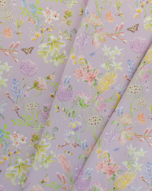 Draped Hopeful Beginnings cotton twill fabric in pink showing detailed botanical floral and butterflies pattern.