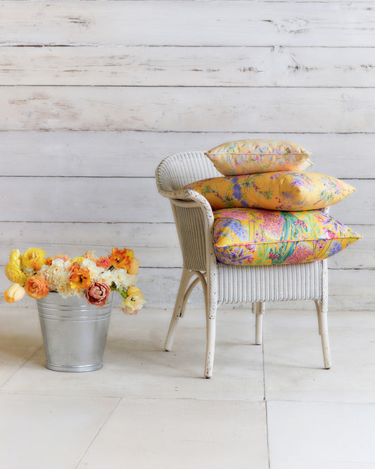 Interior featuring Hopeful Beginnings yellow botanical fabric used for curtains and decorative cushions.