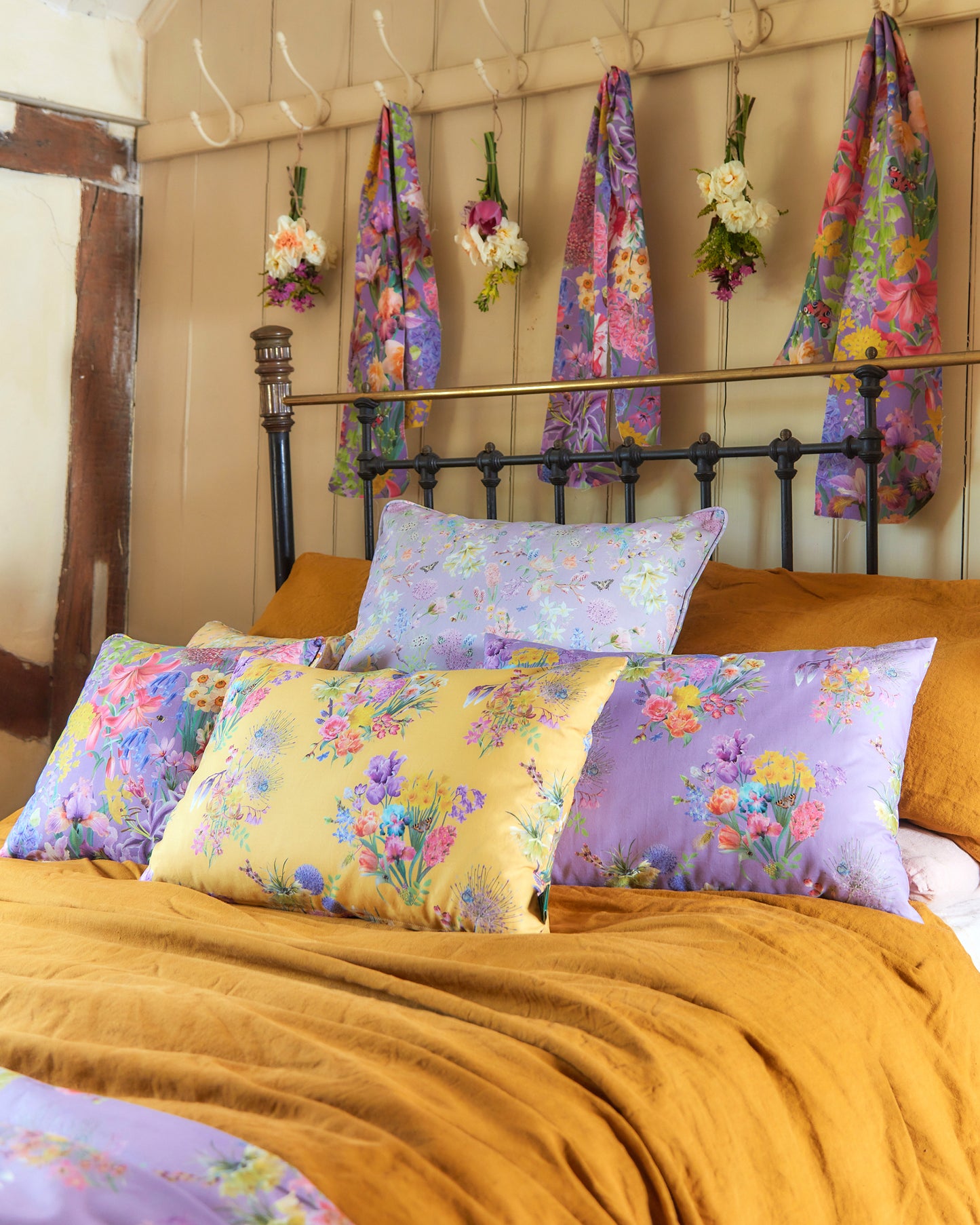 Energising bedroom interior design inspiration filled with yellow and purple soft furnishings in luxury floral prints