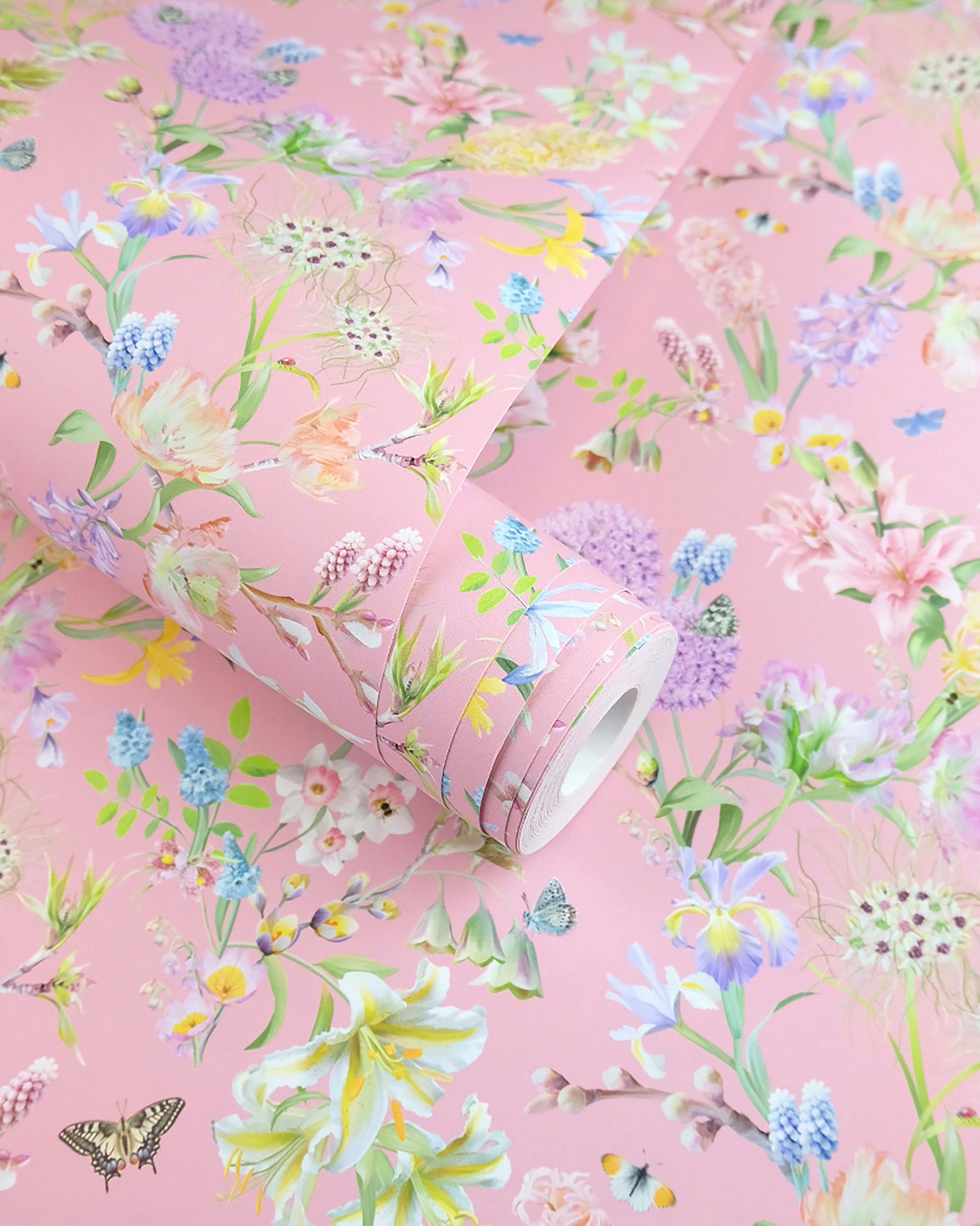 A roll of soft pink neutral wallpaper with a spring botanical print for traditional cottage interior design