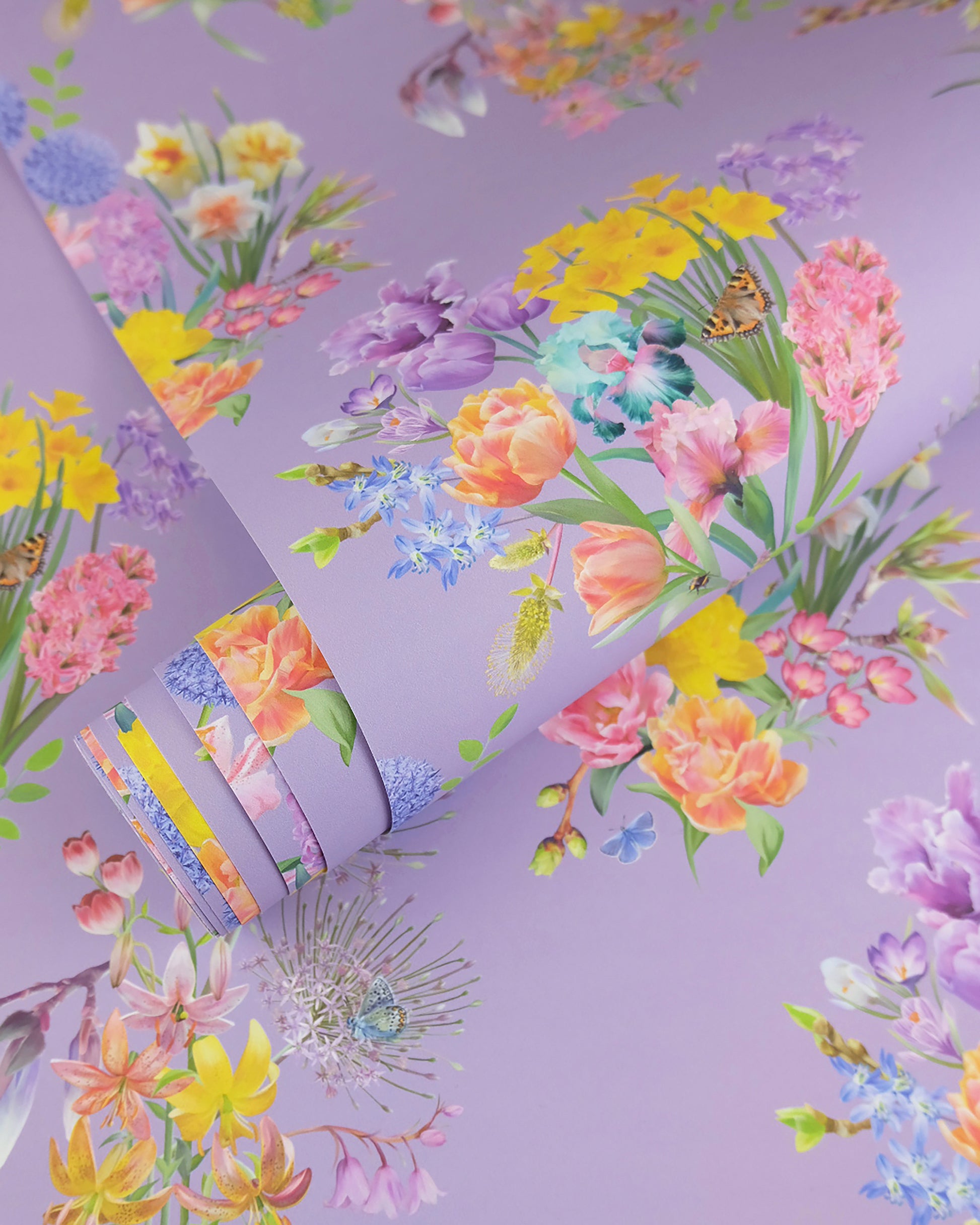 A roll of maximalist designer wall covering in magenta with a spring botanical print for modern interiors